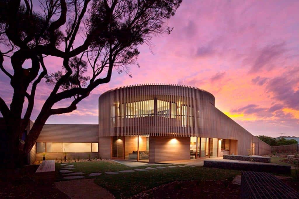 Rectangular Wooden House With Slatted Circular Facade